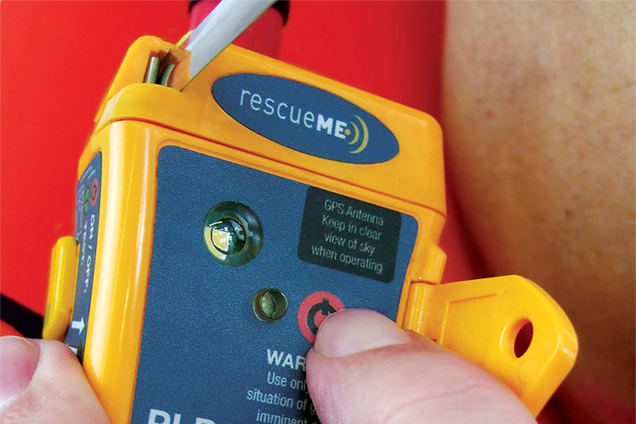 Extreme close up of a thumb hovering over the SOS button on the RescueMe PLB1.