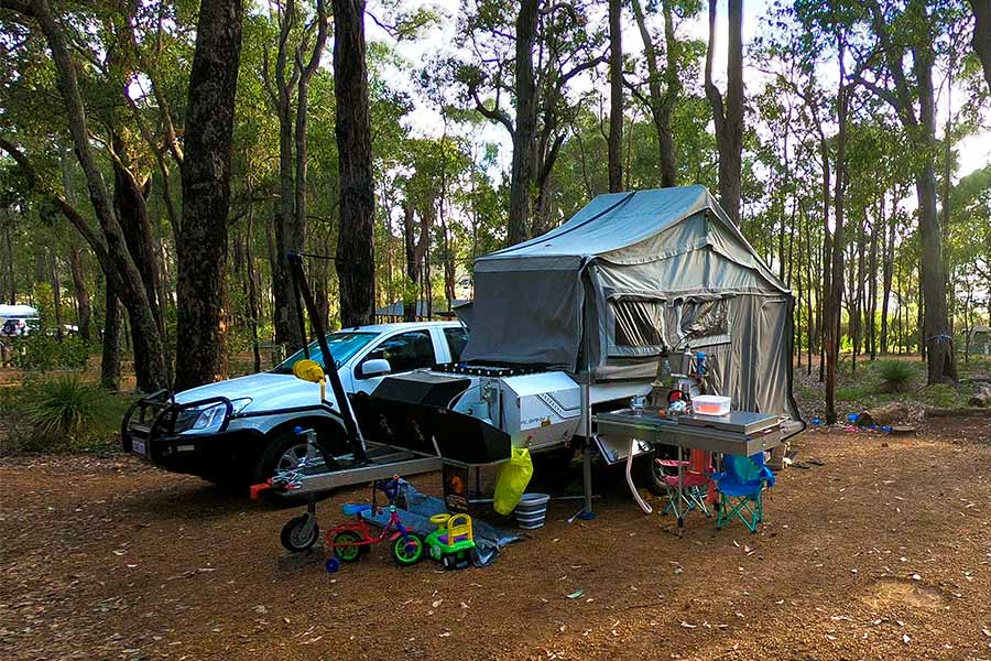 Hard floor camper trailer setup lângă vehicul în aer liber