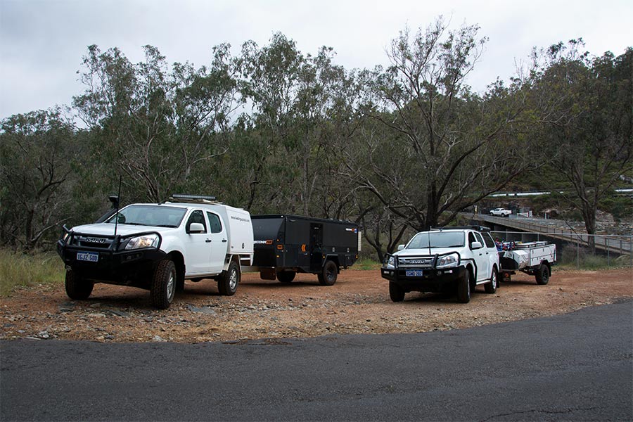  Deux 4 roues motrices conduisant l'une à côté de l'autre, chacune remorquant des remorques de camping-car à l'arrière 