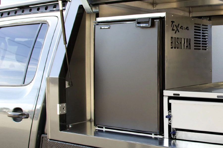 A camping fridge in the back of a vehicle.